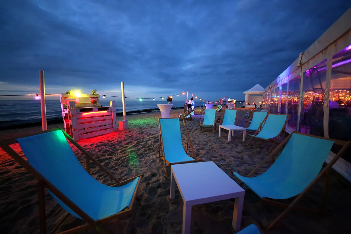 Lounge mit Strandkörben und warmem Licht am Strand
